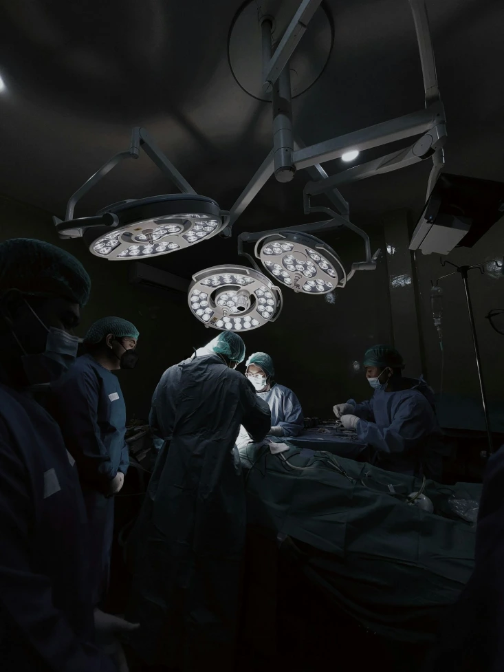 A group of doctors standing around a hospital bed